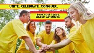 A smiling corporate team wearing matching yellow shirts putting their hands together in a huddle outdoors, featuring text banners that read UNITE CELEBRATE CONQUER and BOOK YOUR TEAMS WILDEST ADVENTURE.